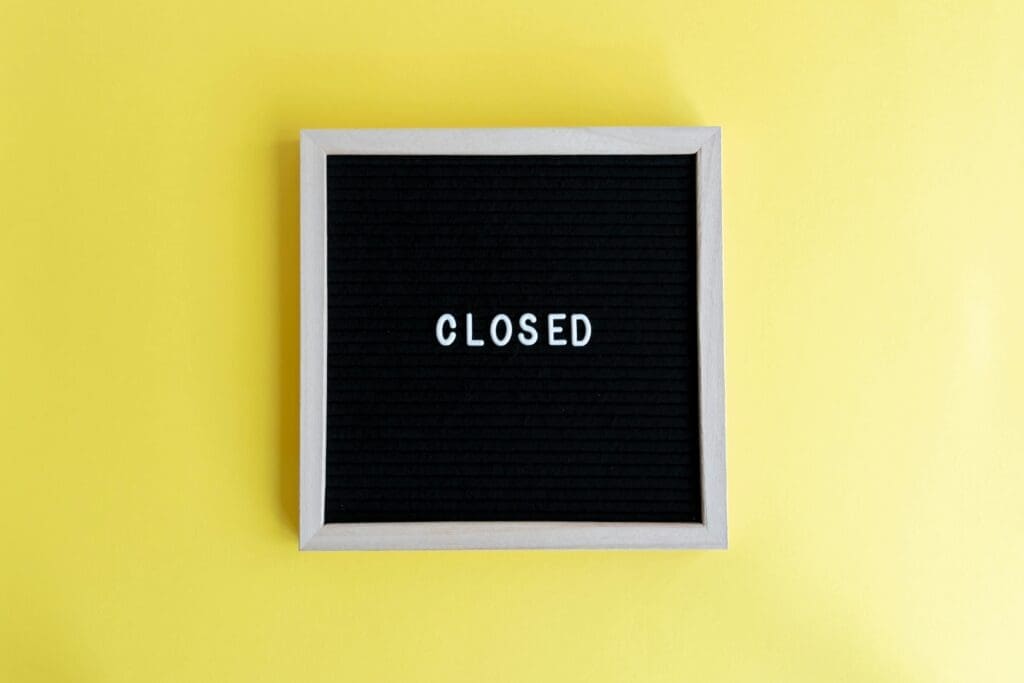 Black letter board with the word 'CLOSED' on a vibrant yellow background. Ideal for business use.